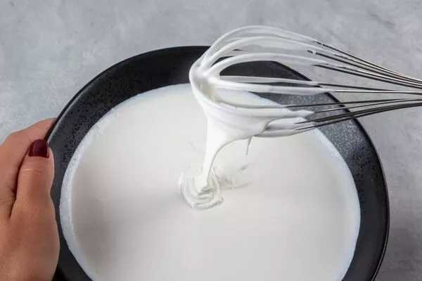 pouring domino powdered sugar glaze onto bundt cake