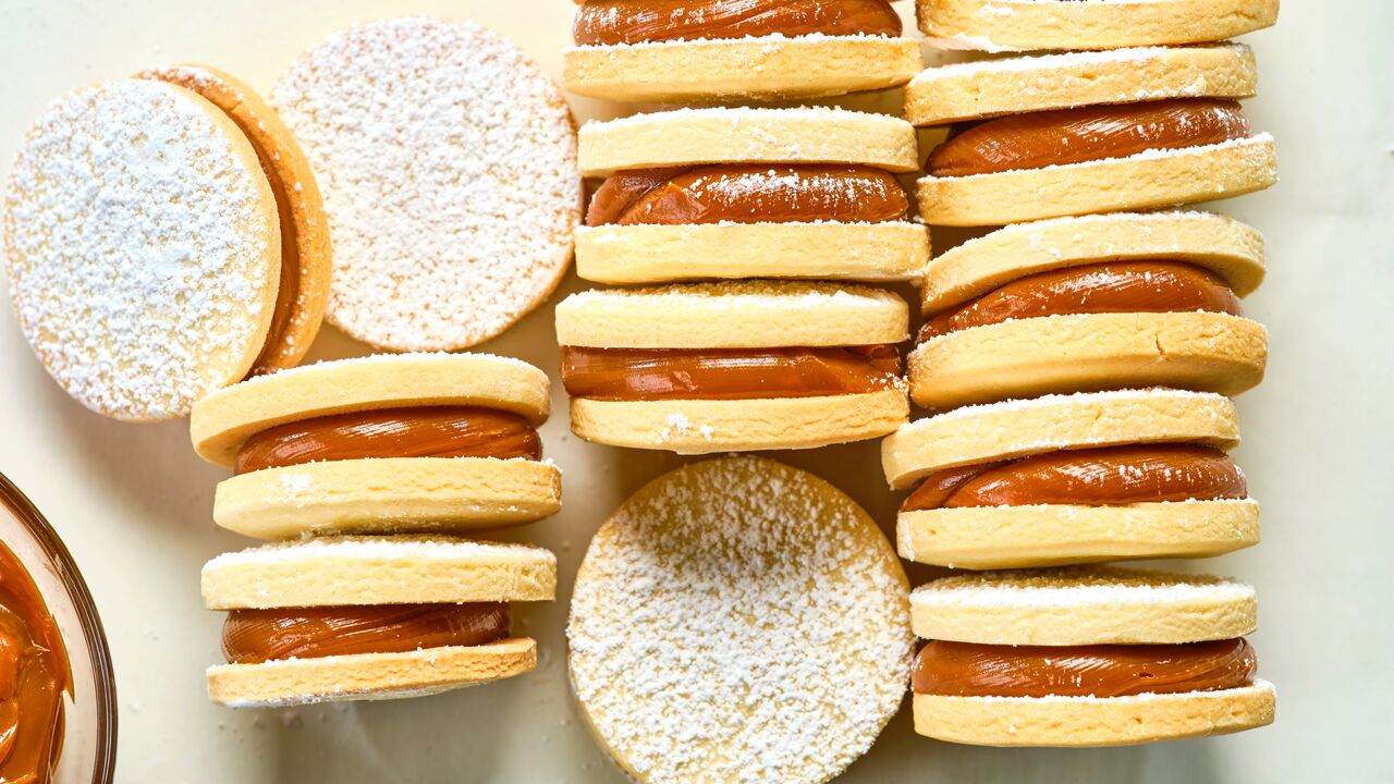 caramel-filled sandwich cookies dusted with powdered sugar arranged on a countertop